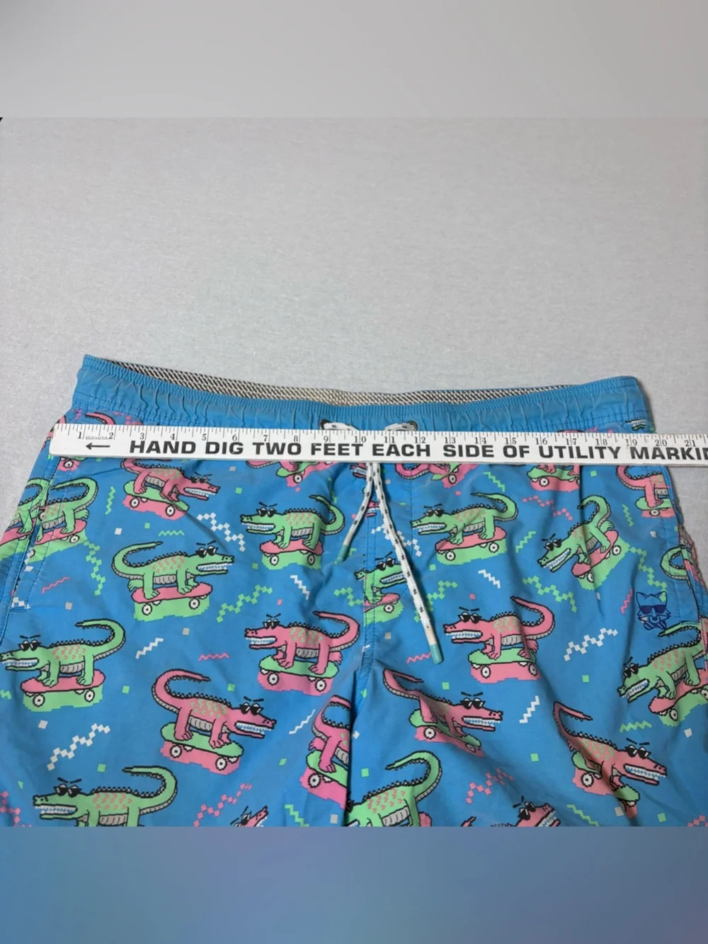 blue Party Pants swim trunks with an all-over neon alligator